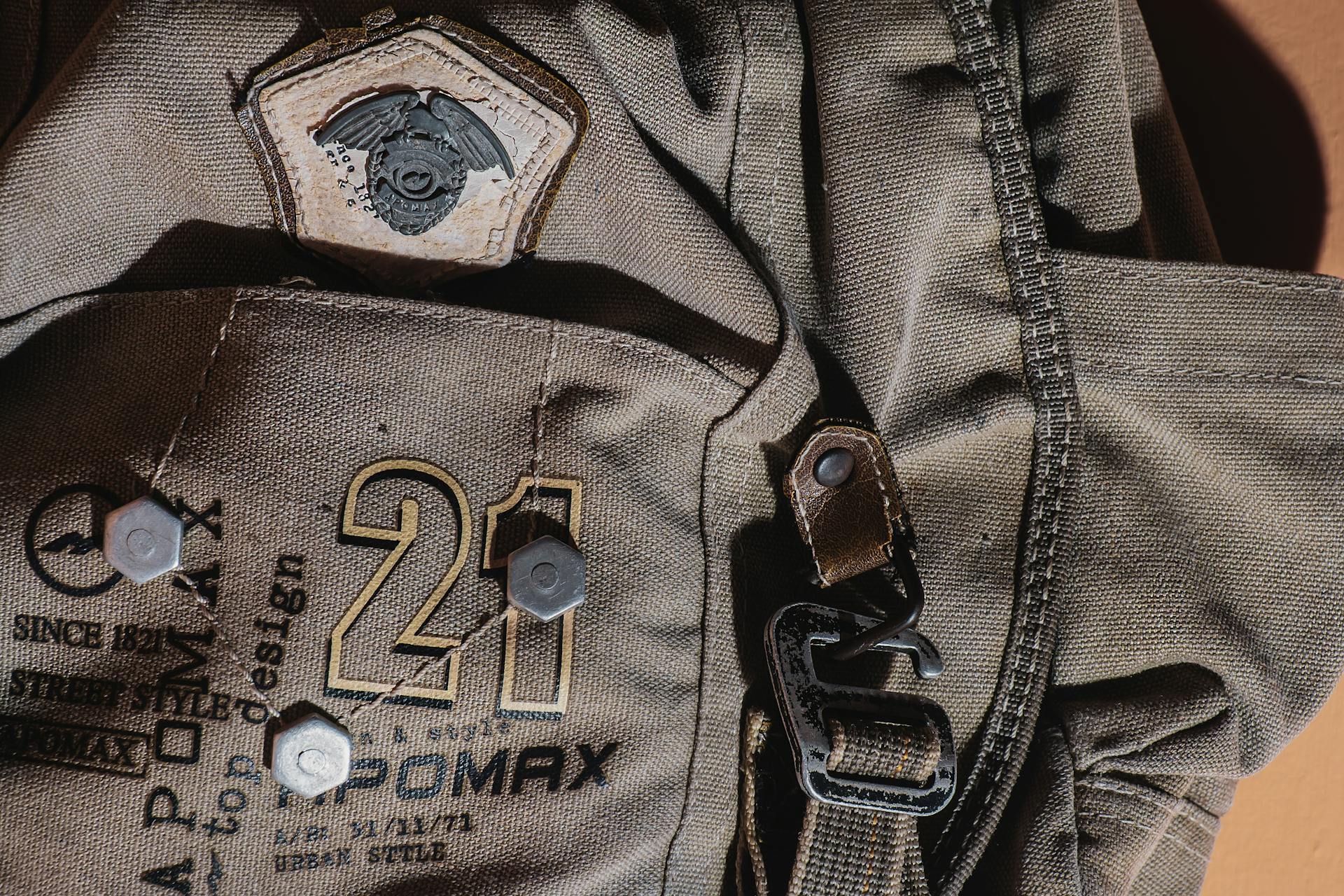 Detailed close-up of a rugged canvas backpack with military patch and metal hardware.