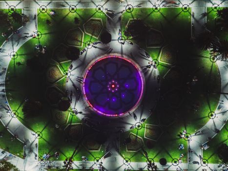 Stunning aerial shot of a brightly illuminated plaza in Istanbul, showcasing intricate patterns and vibrant lights at night.
