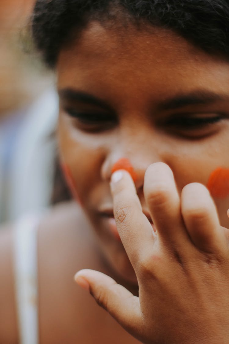 A Woman Putting Paint On Her Face