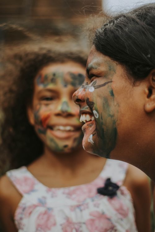 Free Two girls with colorful face paint sharing a joyful moment outdoors, exuding happiness and friendship. Stock Photo