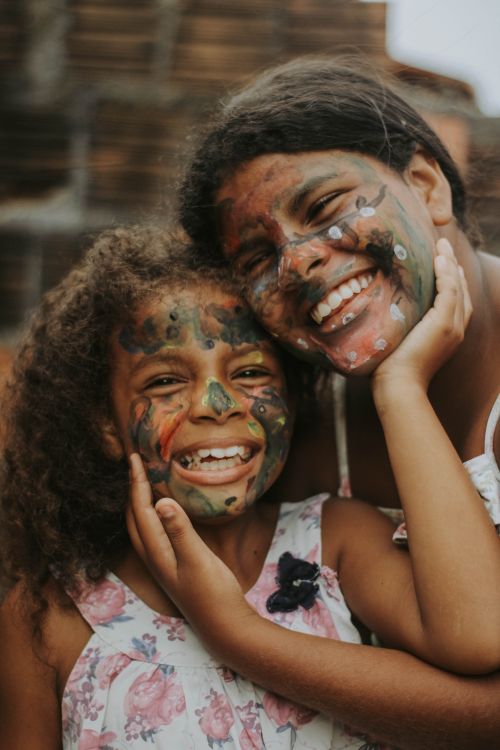 Free Two smiling individuals with painted faces sharing a joyful moment outdoors. Stock Photo