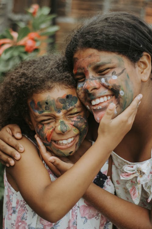 Girls with Painted Faces Hugging 