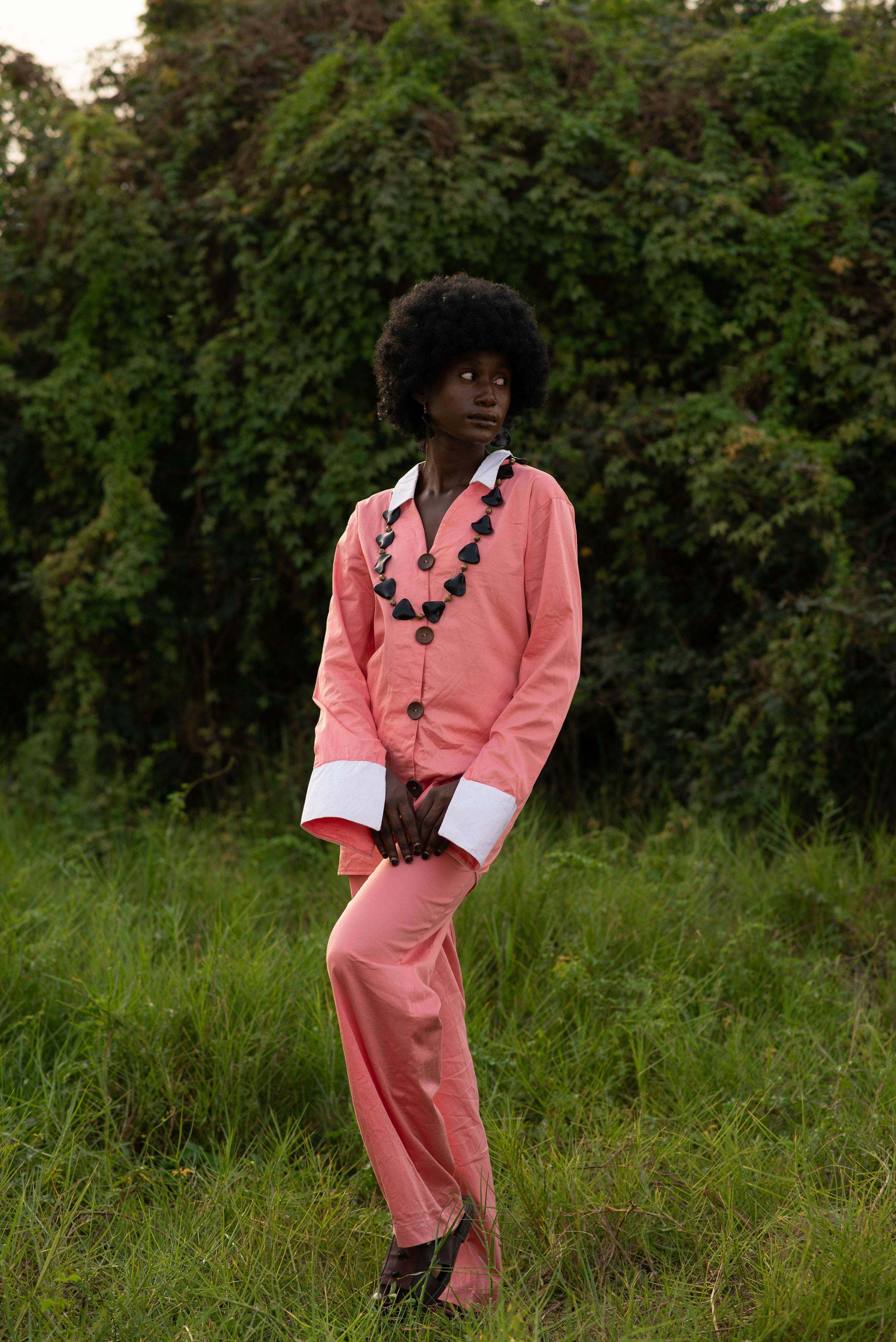 De franc Dona Amb Camisa De Màniga Llarga Rosa I Blanca Dempeus Al Camp D'herba Foto d'estoc