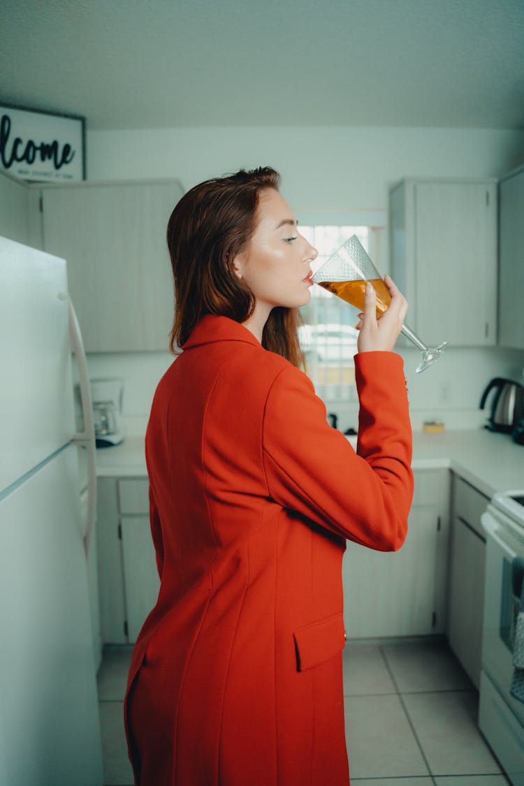 Woman In Red Outfit Drinking A Cocktail In The Kitchen 