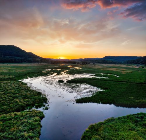 Free Explore the serene sunset view over a lush river and fields in Alma, Wisconsin. Stock Photo