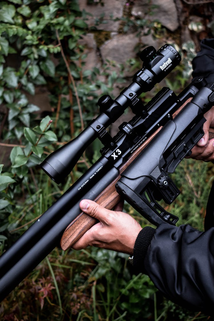 Close-up Of Holding A Gun With Scope