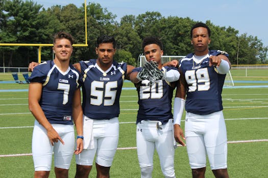 A team of young adult football players posing confidently on the field.