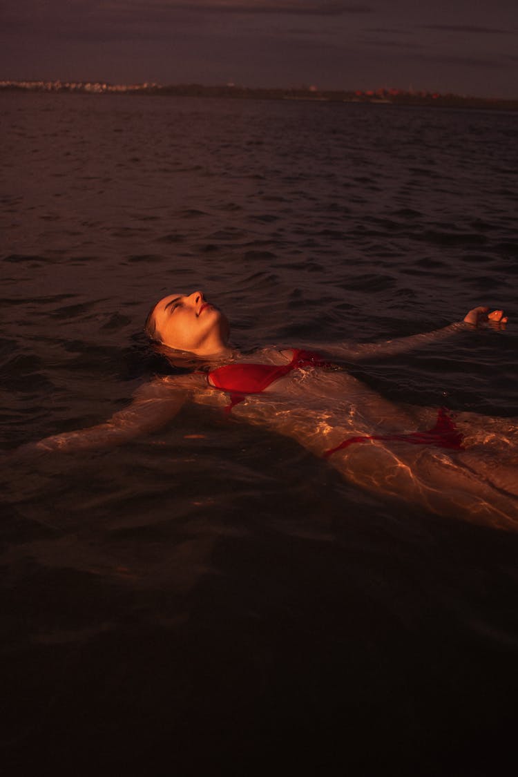 Woman In Red Bikini Swimming On Water