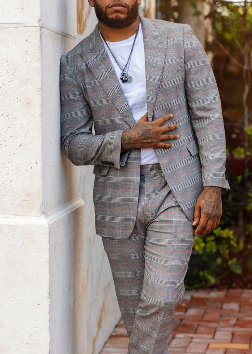 Free Stylish man wearing a plaid suit poses confidently outdoors, highlighting contemporary fashion. Stock Photo