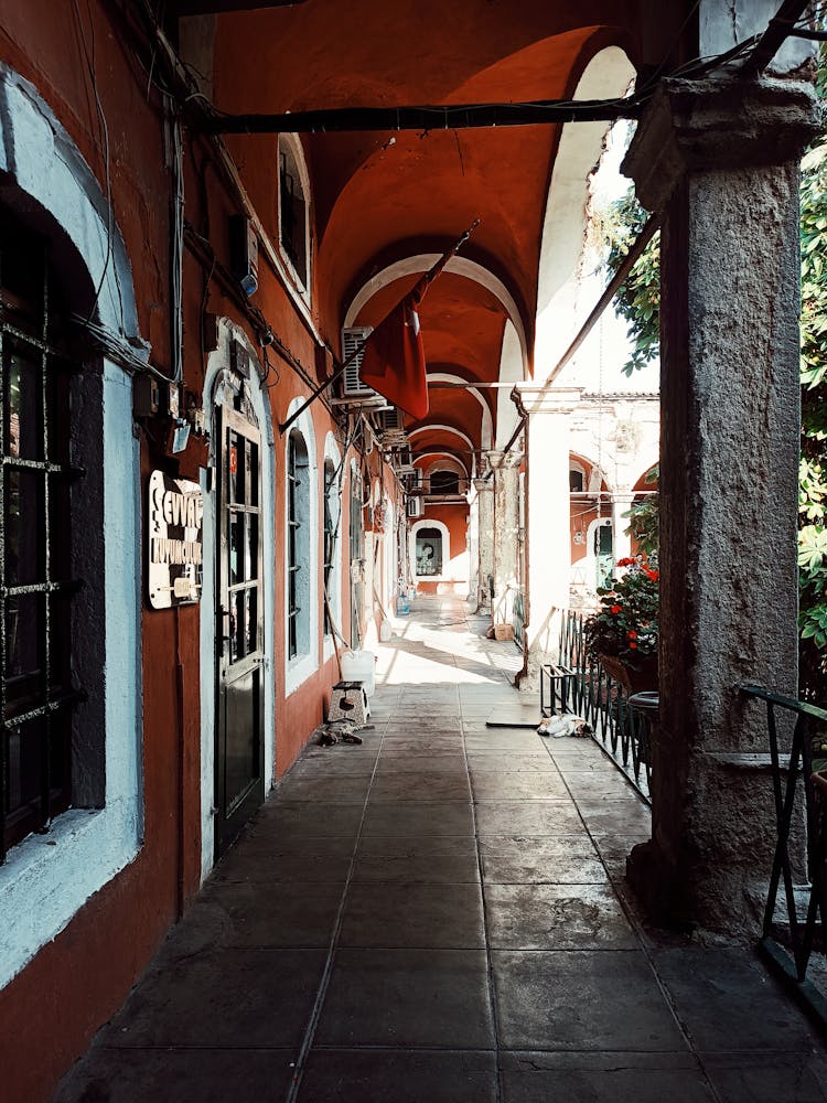 A Narrow Paved Outdoor Hallway Of A Building