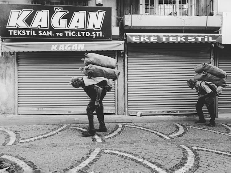 Elderly Men Carrying Heavy Sacks