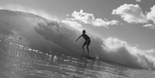 Free Monochrome image of surfer catching a powerful wave, showcasing surf action. Stock Photo