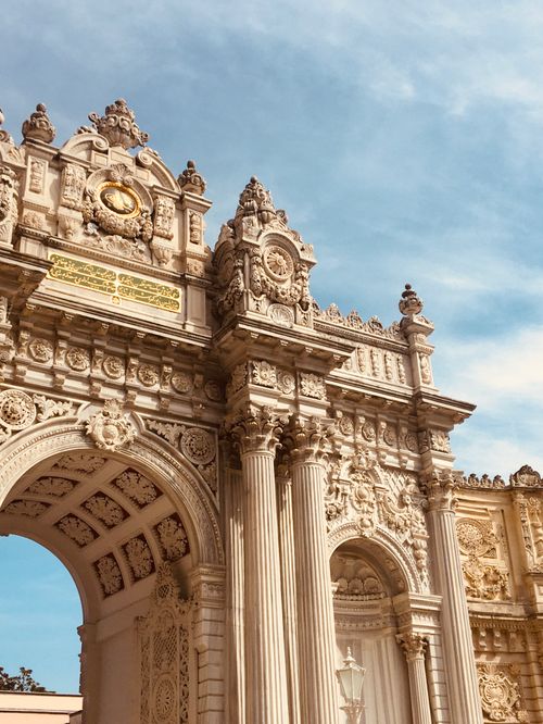 Free Intricately designed neoclassical archway with ornate details against a blue sky. Stock Photo