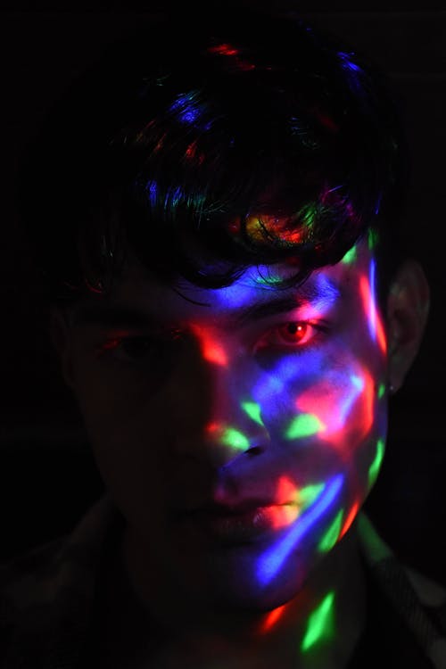 Portrait of Man with Face Illuminated by Neon Lights