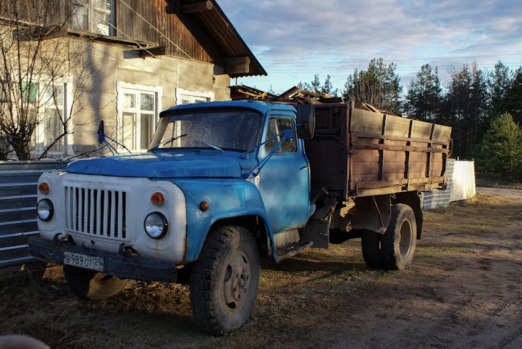 Blue Truck On Dirt Ground Near A House