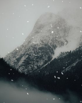 A breathtaking view of a snow-covered mountain during a winter storm, capturing nature's serene beauty.