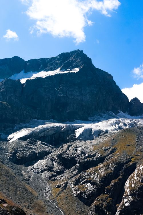 Free Captivating view of a snow-capped mountain peak under a clear blue sky with rugged terrain. Stock Photo