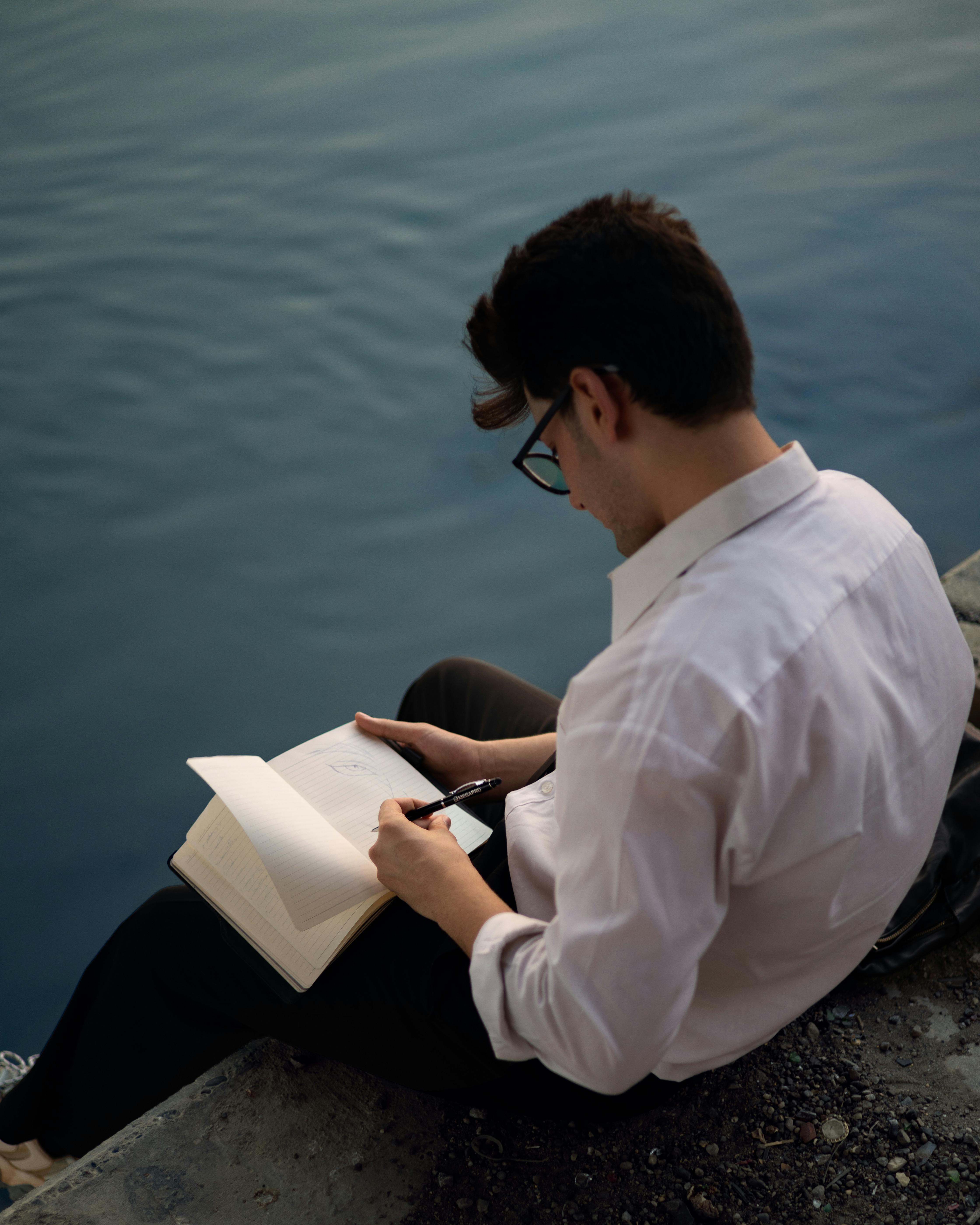 A Person Writing on a Notebook · Free Stock Photo