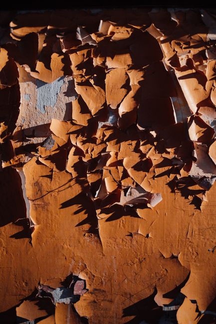 Detailed texture of orange peeling paint on a wall, showing decay and age.