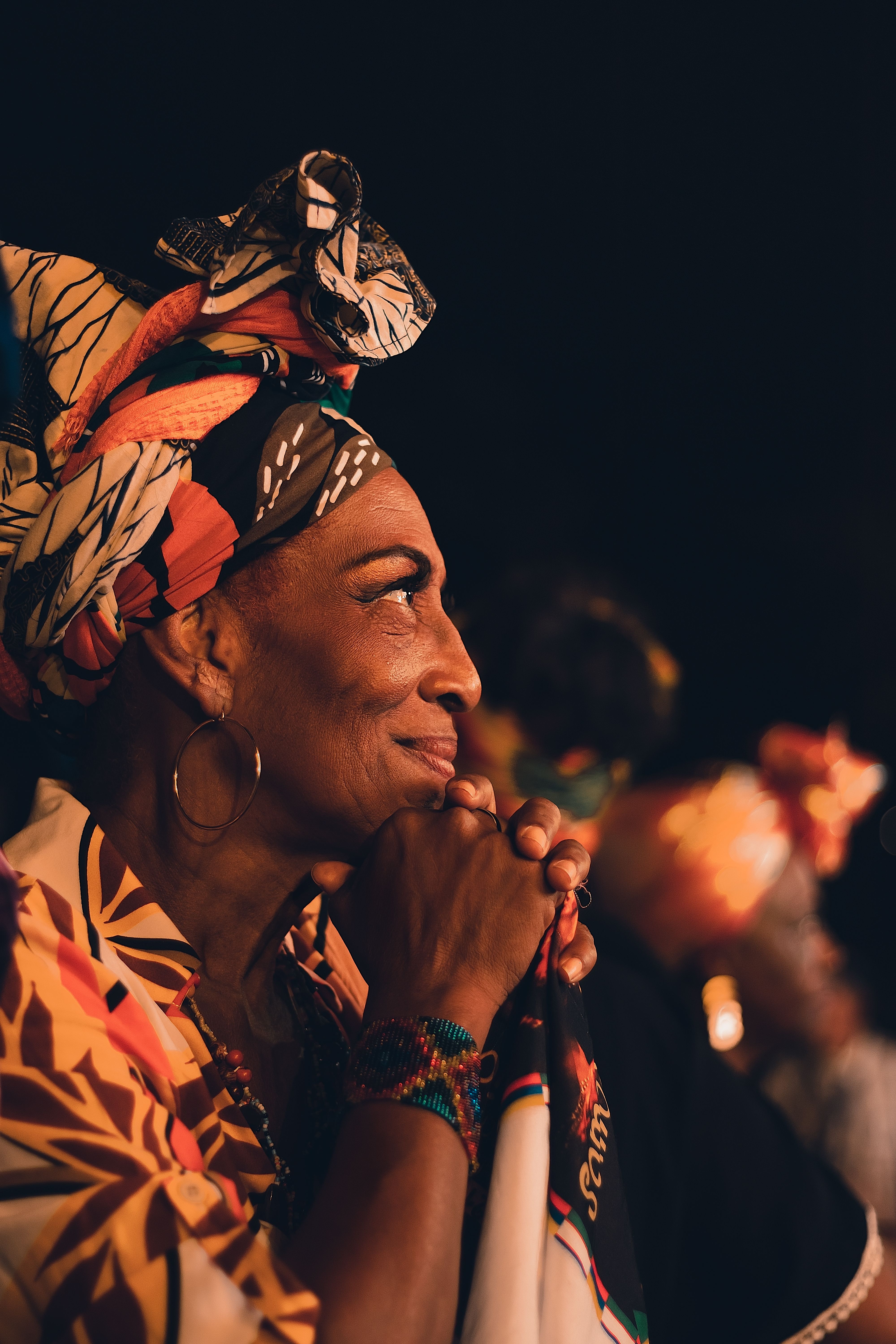 Woman in vibrant headscarf at a nighttime cultural event in Cali