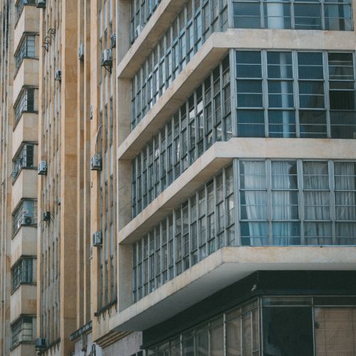 Free Low angle shot of a modern office building facade in Cali, Colombia with glass windows and air conditioning units. Stock Photo