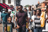 A bustling street in Accra, Ghana, with people walking in a lively urban setting.