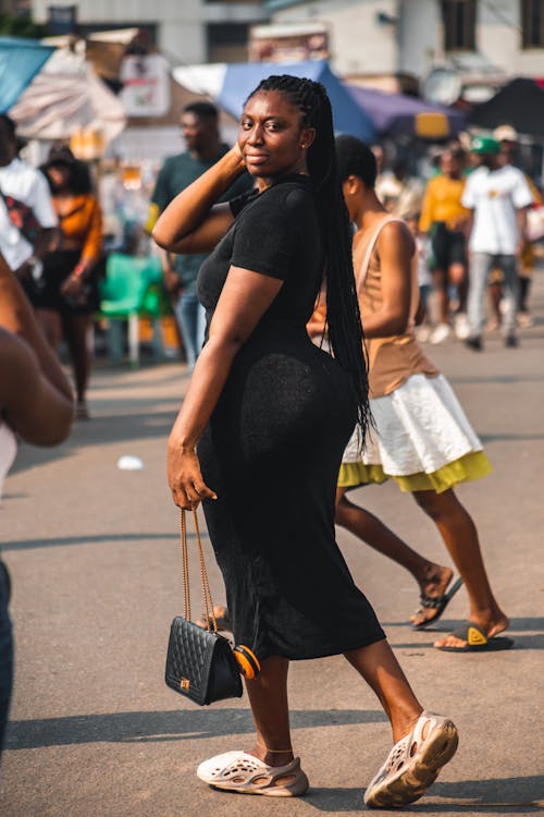 A Woman in Black Dress Posing at the Camera