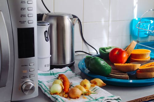 Фотография овощей рядом с серым электрическим чайником