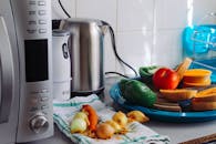 这个现代化的家庭厨房柜台，摆放着新鲜蔬菜和电器，是健康烹饪的理想选择