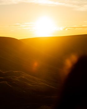 A breathtaking sunrise casting warm golden hues over rolling hills during the golden hour.