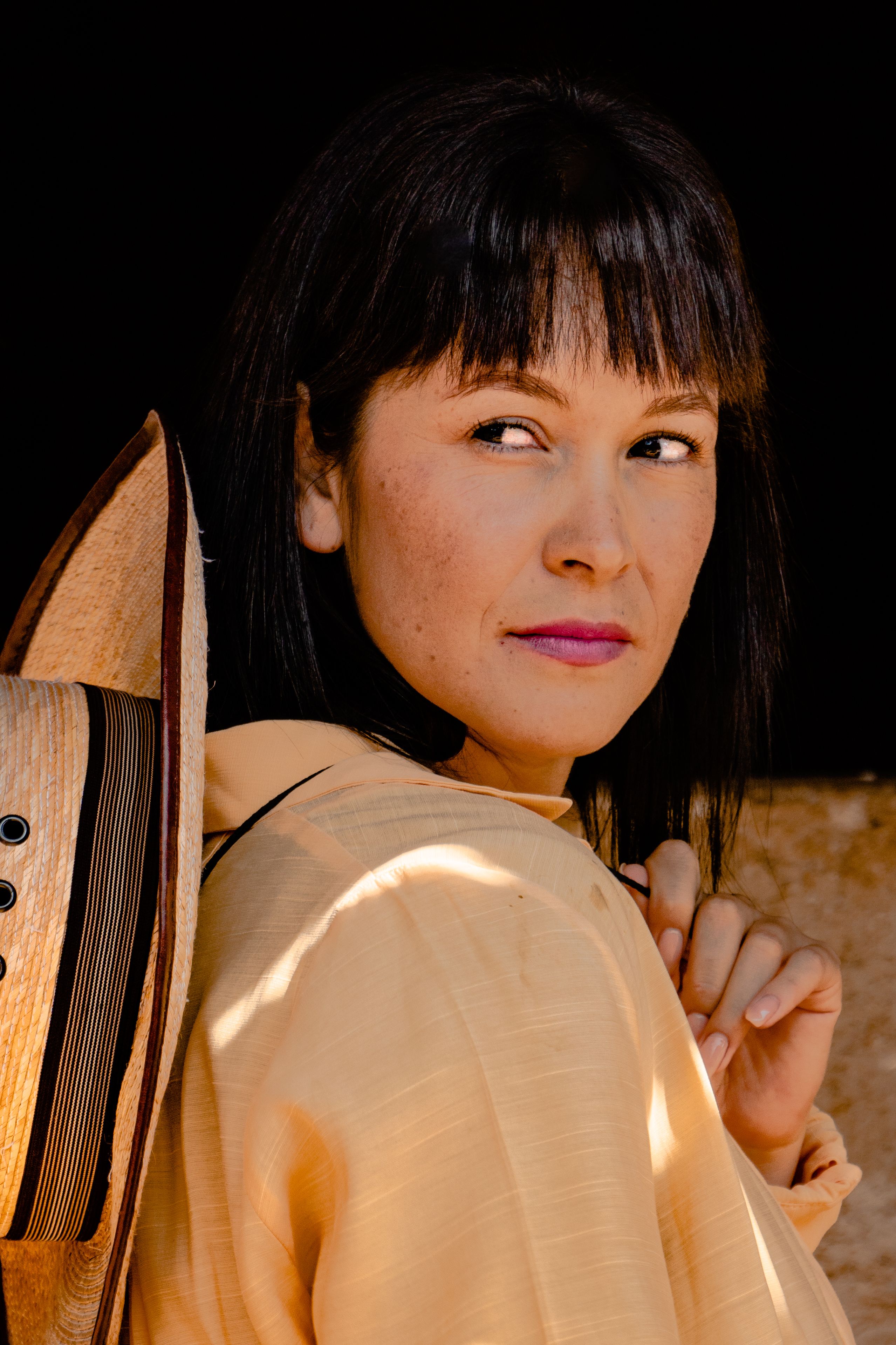 Elegant portrait of a woman with dark hair wearing a traditional Mexican hat.