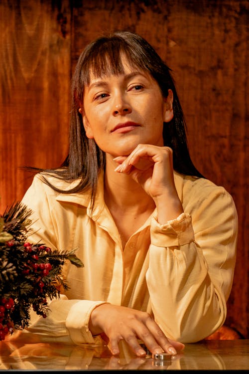 A Woman in Yellow Long Sleeves with Her Hand on Her Chin