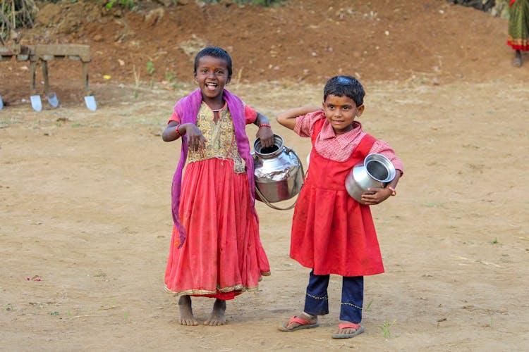 Girls In Traditional Dresses On Sand Ground 