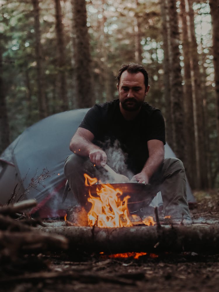 Man Cooking While In Camping