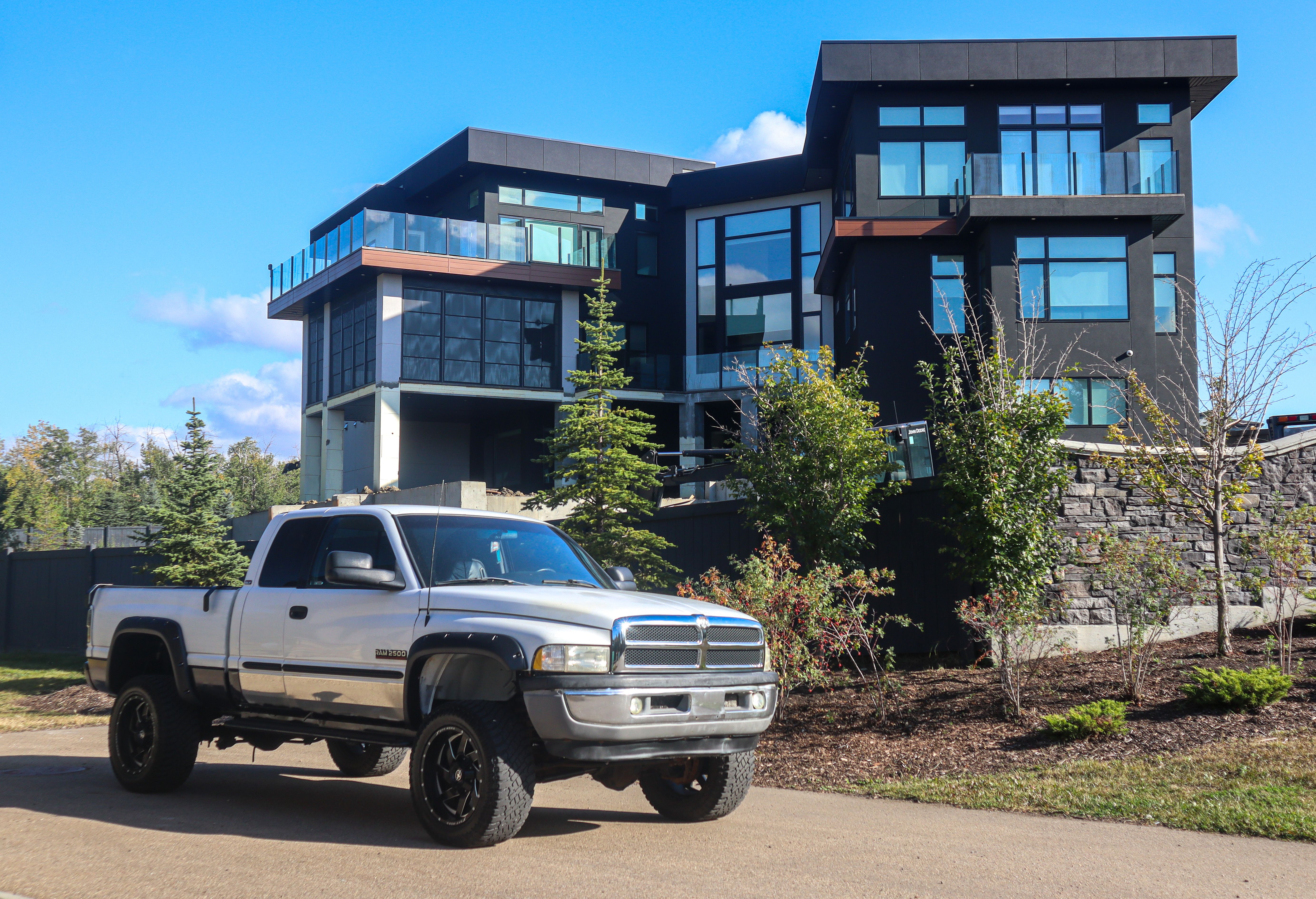 Stylish modern home with a parked silver pickup truck outdoors under a clear blue sky.
