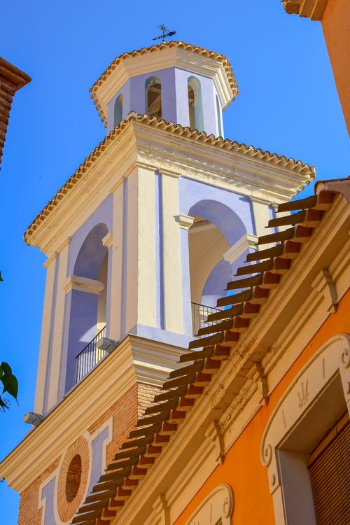 Free A charming church tower in Mula, Spain, set against a vivid blue sky. Stock Photo