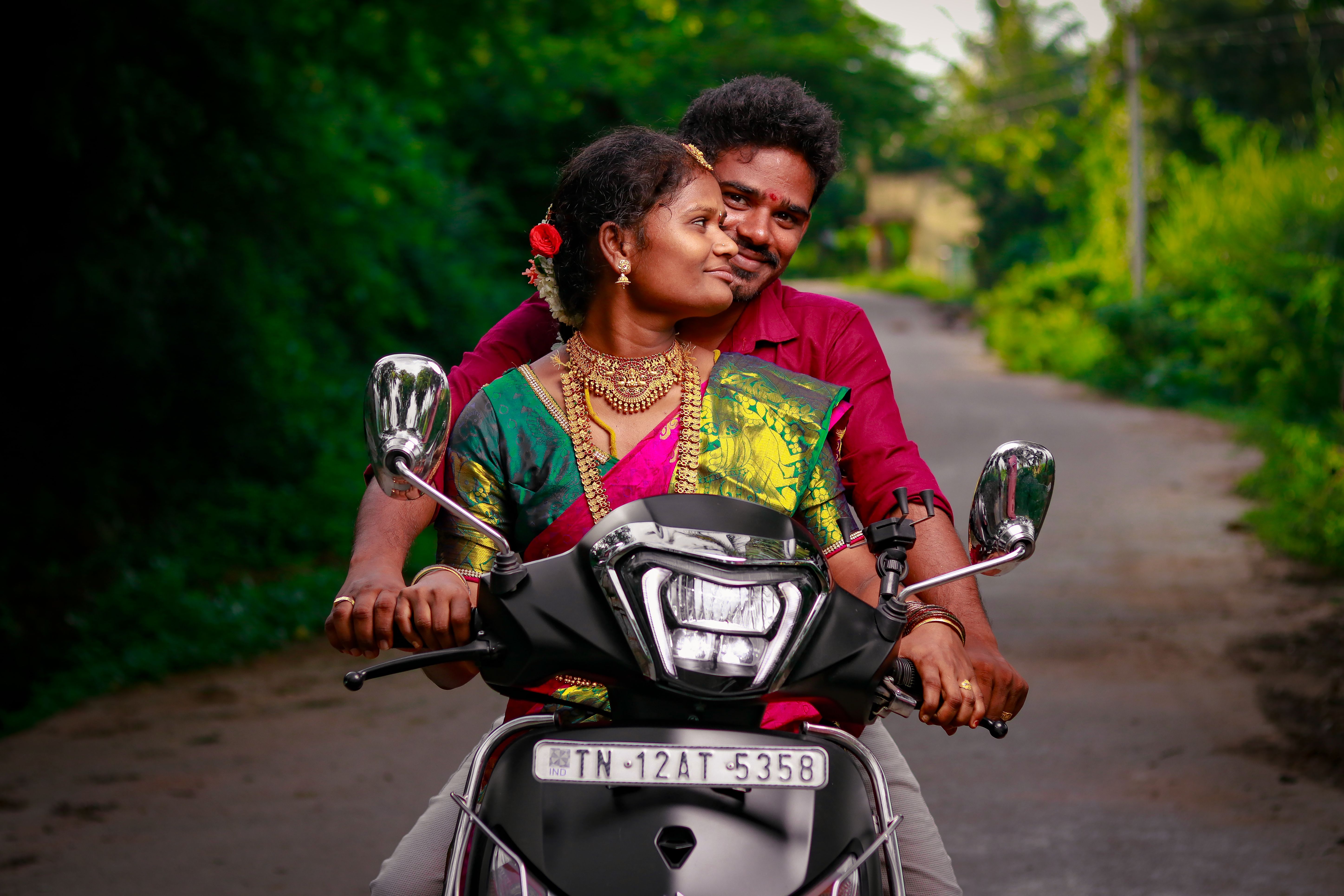 Joyful couple riding a scooter through a lush green countryside. Captured love and happiness.