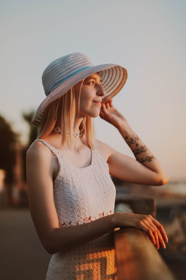 Woman In Summer Hat On Beach On Sunset