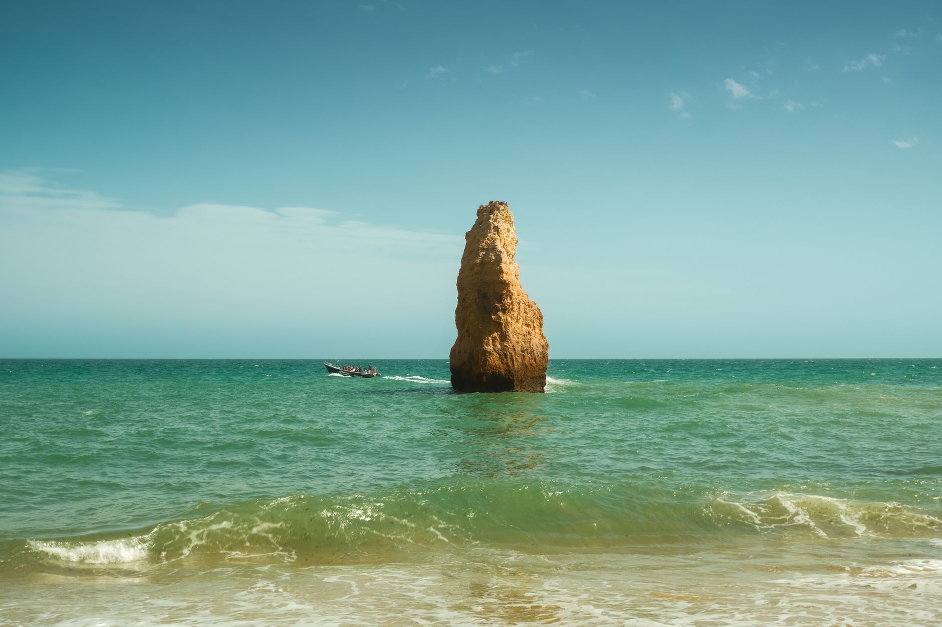 Beach scene with rock formation and boat