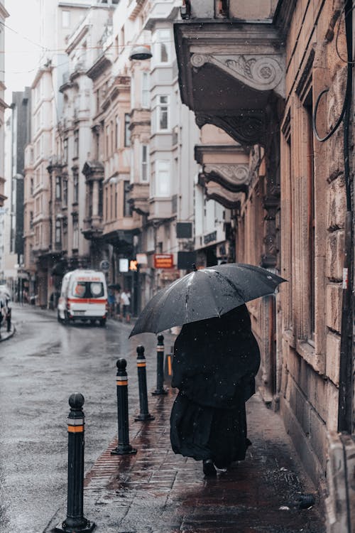 Woman under Umbrella Walking Old City Street