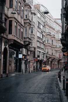 A serene street scene in Istanbul showcasing classic architecture and a yellow taxi.