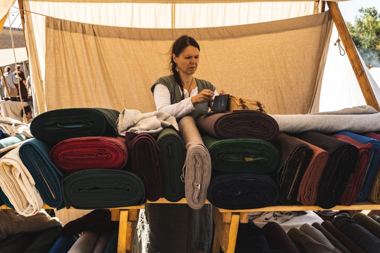 Woman Putting Bag Above Fabrics