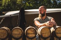 Man Standing in Front of Oak Barrels