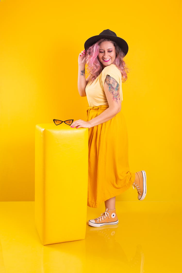 Woman In Yellow Clothes Posing In Yellow Studio