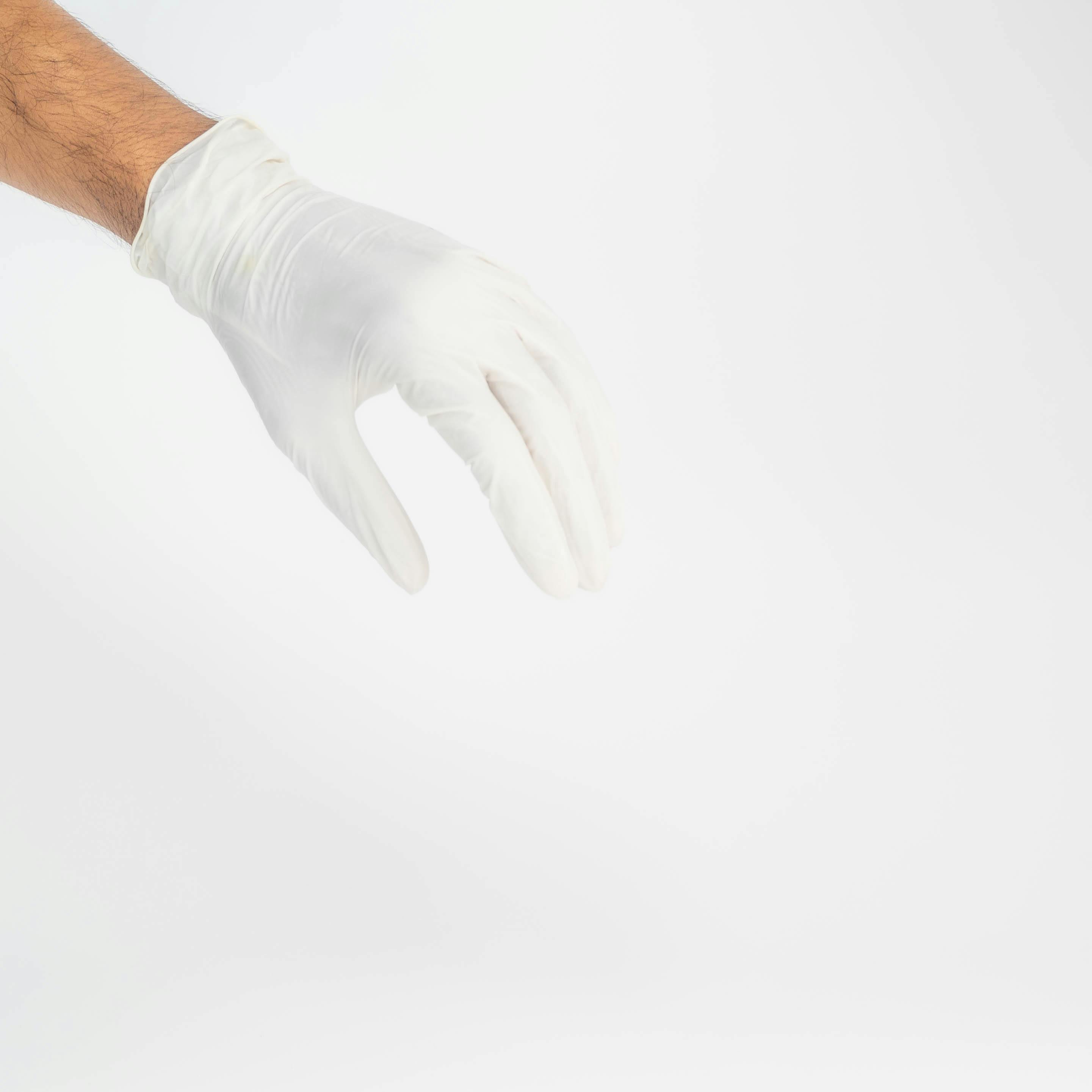 Close-up of a hand wearing a white glove against a white background, symbolizing hygiene and care.