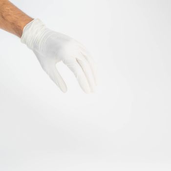 Close-up of a hand wearing a white glove against a white background, symbolizing hygiene and care.