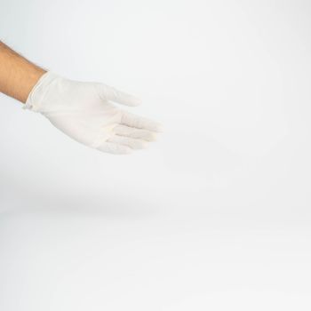 White-gloved hand extended with an offering gesture against a plain background.