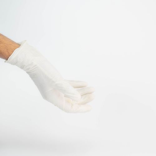 Free White latex glove on hand, illustrating sterile healthcare practices. Stock Photo
