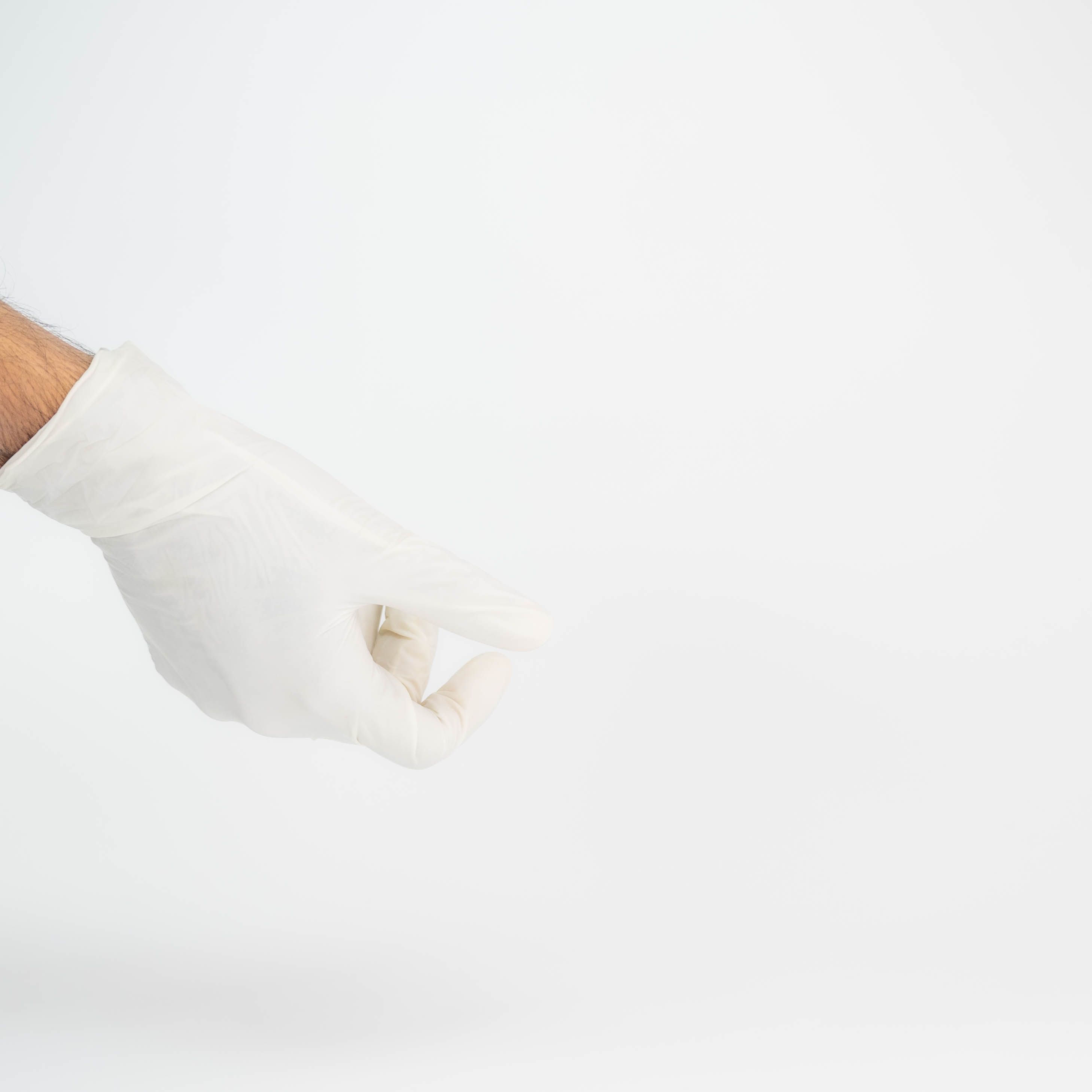 Close-up image of a hand in a white glove against a white background, showcasing elegance and simplicity.
