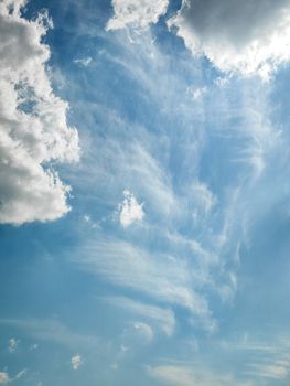Vivid blue sky with wispy and fluffy clouds, perfect for serene backgrounds.